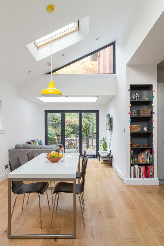 Contemporary open plan dining room in Glasgow with white walls, light hardwood flooring and blue floors.