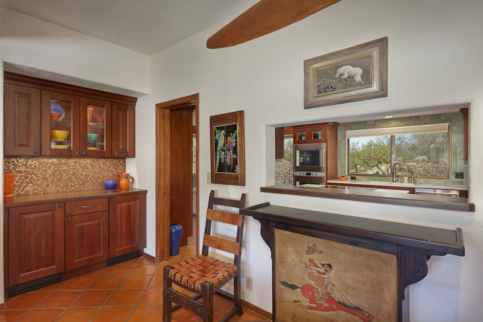 Aménagement d'une grande salle à manger ouverte sur la cuisine classique avec un mur blanc, tomettes au sol et un sol marron.