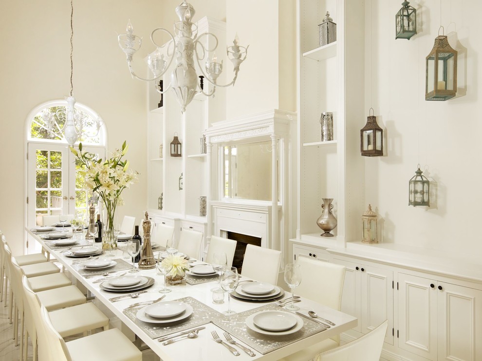 Immagine di una sala da pranzo design con pareti bianche e camino classico