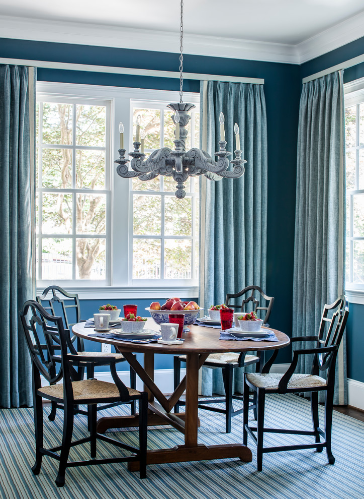 Réalisation d'une salle à manger tradition avec un mur bleu, parquet foncé et un sol marron.