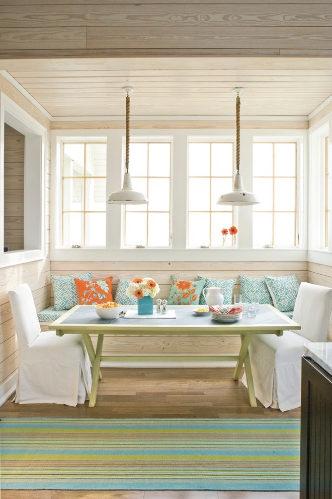 Foto di una sala da pranzo aperta verso la cucina stile marinaro con pavimento in legno massello medio
