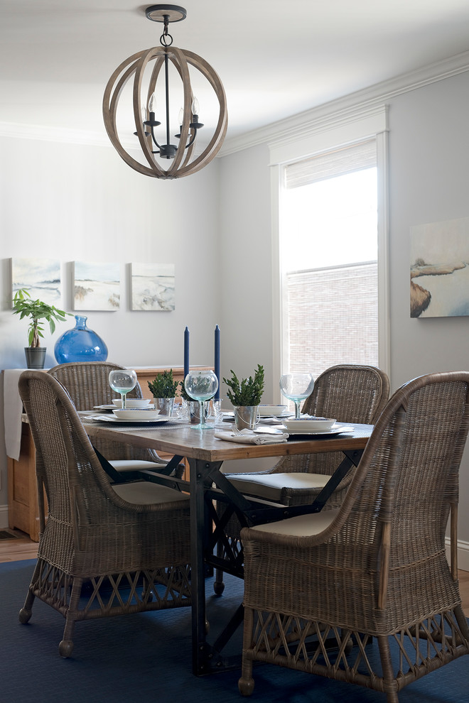 Immagine di una sala da pranzo aperta verso la cucina stile marino con pareti bianche