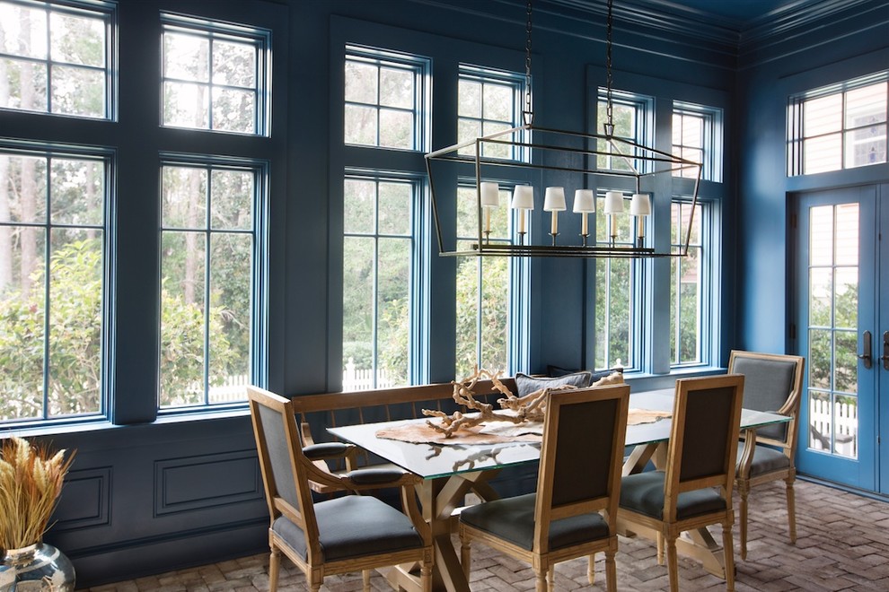 Cette image montre une grande salle à manger ouverte sur le salon marine avec un mur bleu, un sol en brique, aucune cheminée et un sol multicolore.
