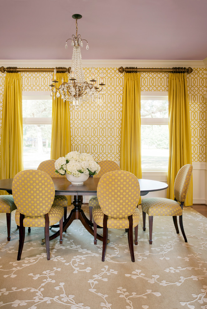 Cette image montre une salle à manger traditionnelle fermée et de taille moyenne avec un mur jaune et un sol en bois brun.