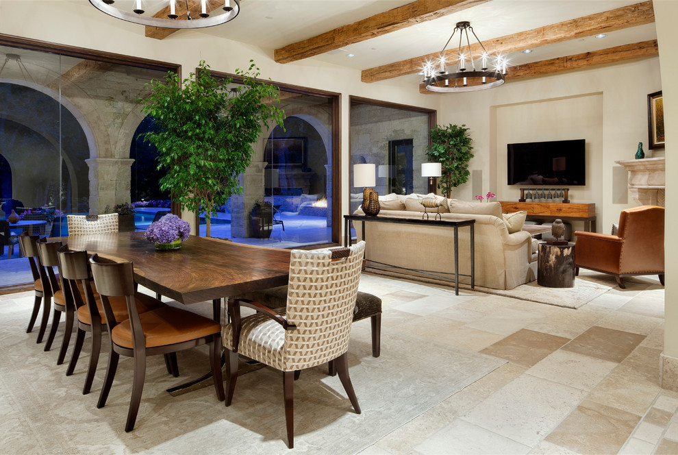 Immagine di una sala da pranzo aperta verso il soggiorno mediterranea con pareti beige e pavimento beige