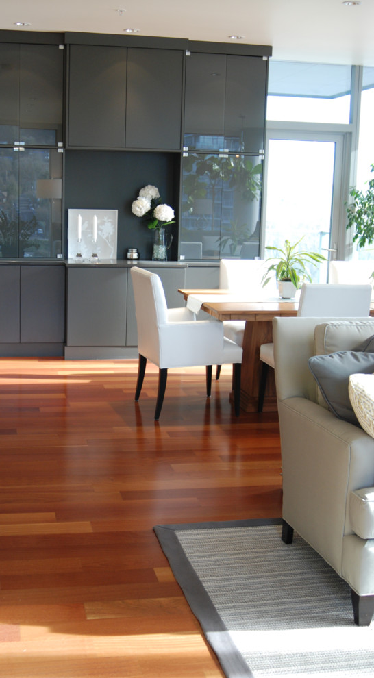 Aménagement d'une salle à manger contemporaine avec un mur gris et un sol en bois brun.