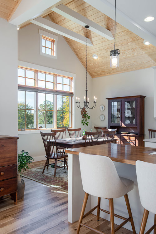 Idee per una sala da pranzo aperta verso la cucina stile rurale con pareti bianche, parquet chiaro, pavimento marrone e soffitto a volta