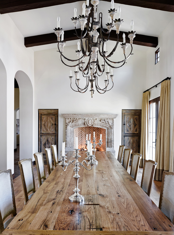 Idée de décoration pour une grande salle à manger méditerranéenne avec un mur blanc et une cheminée standard.