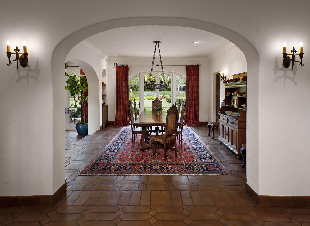 This is an example of a mediterranean dining room in Santa Barbara with white walls, no fireplace and terracotta flooring.
