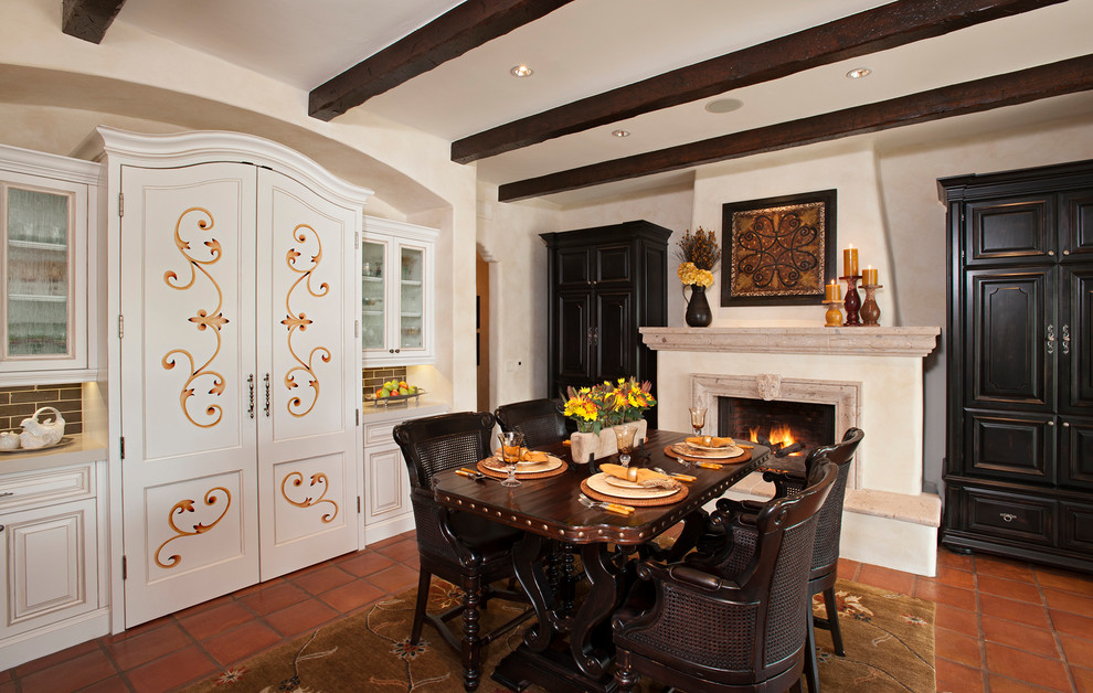 Design ideas for a mediterranean dining room in Phoenix with white walls and a standard fireplace.