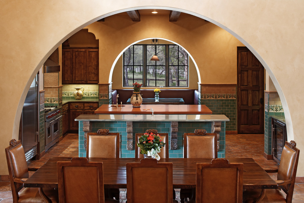 Immagine di una sala da pranzo aperta verso la cucina mediterranea con pavimento in terracotta
