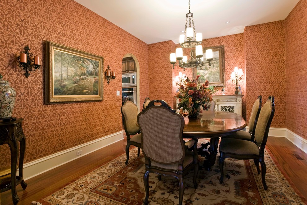 Geschlossenes, Mittelgroßes Klassisches Esszimmer ohne Kamin mit oranger Wandfarbe, dunklem Holzboden und braunem Boden in Sonstige