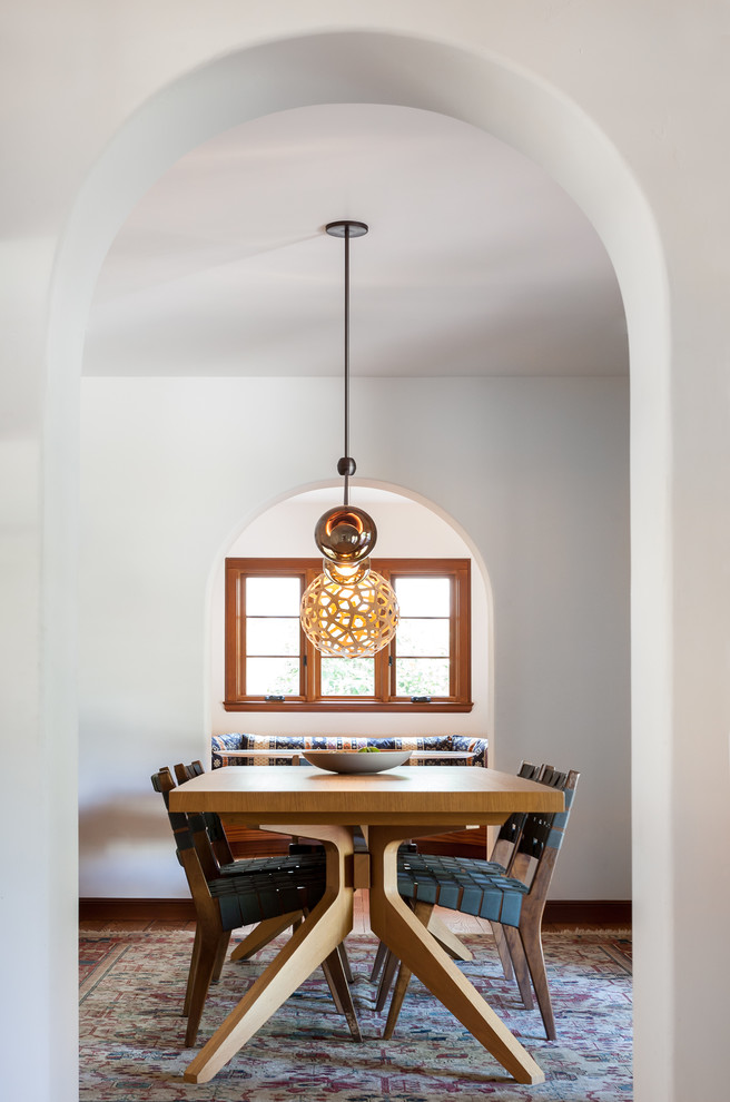 Inspiration for a mediterranean enclosed dining room in Sacramento with white walls, medium hardwood flooring and brown floors.