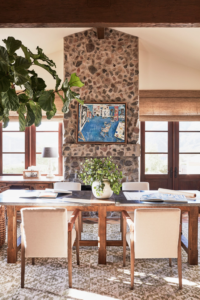 Idée de décoration pour une grande salle à manger méditerranéenne fermée avec un mur beige, une cheminée standard, un manteau de cheminée en pierre et éclairage.