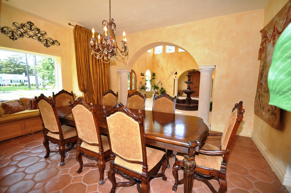 Example of a large tuscan terra-cotta tile enclosed dining room design in Other with yellow walls