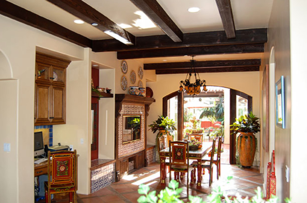 Foto på en mellanstor medelhavsstil separat matplats, med beige väggar, klinkergolv i keramik, rött golv, en standard öppen spis och en spiselkrans i trä
