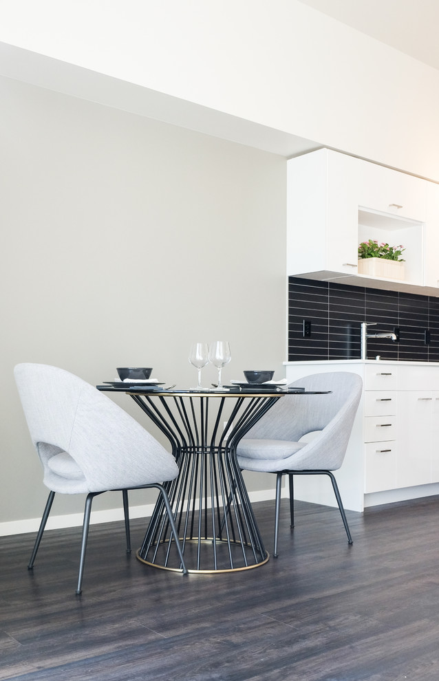 Foto di una piccola sala da pranzo aperta verso il soggiorno minimalista con pareti grigie, pavimento in vinile e pavimento marrone