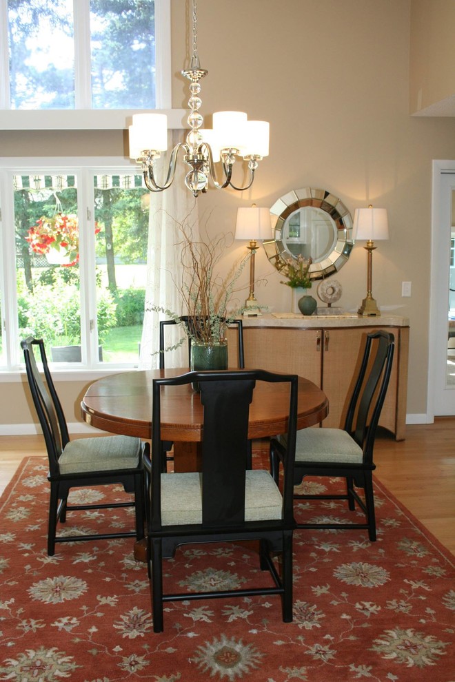 Immagine di una piccola sala da pranzo aperta verso la cucina tradizionale con pareti beige e pavimento in legno massello medio
