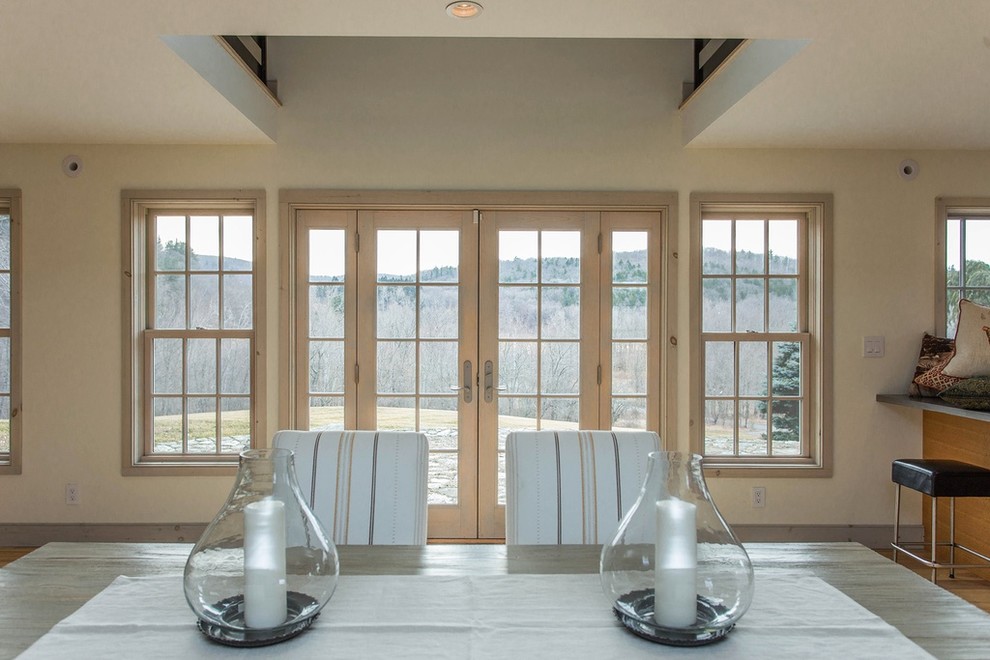 Ispirazione per una sala da pranzo aperta verso la cucina minimalista di medie dimensioni con pareti beige, parquet chiaro e pavimento beige