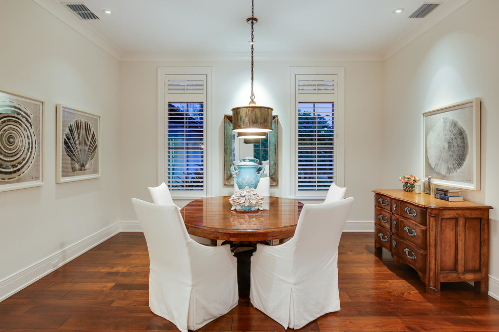 Foto di una grande sala da pranzo aperta verso il soggiorno tropicale con pareti bianche e pavimento in legno massello medio