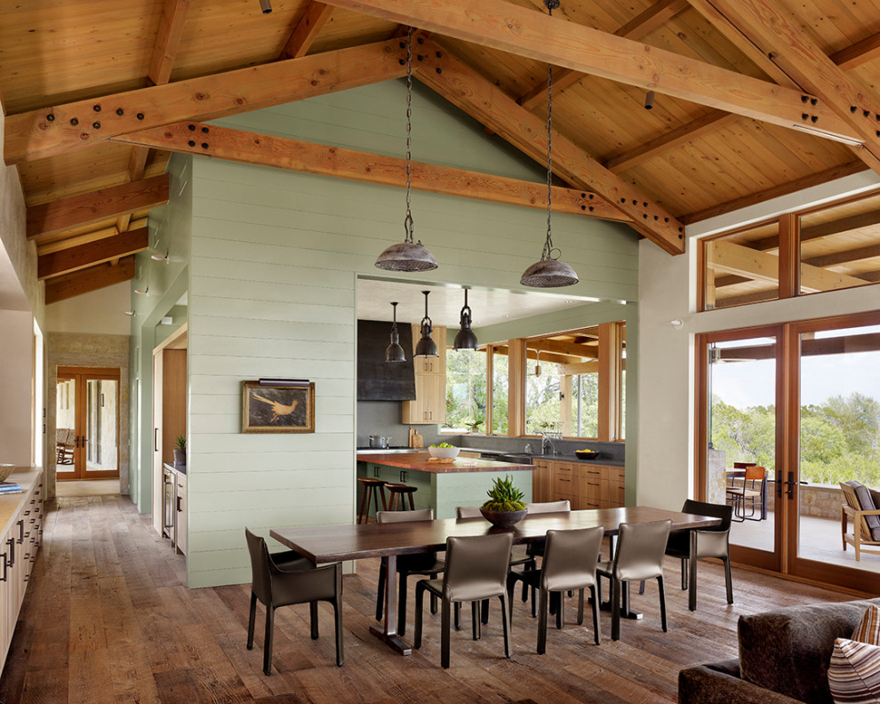 Idées déco pour une très grande salle à manger ouverte sur le salon campagne avec un sol marron, un mur vert, parquet foncé, poutres apparentes, un plafond voûté, un plafond en bois et du lambris de bois.