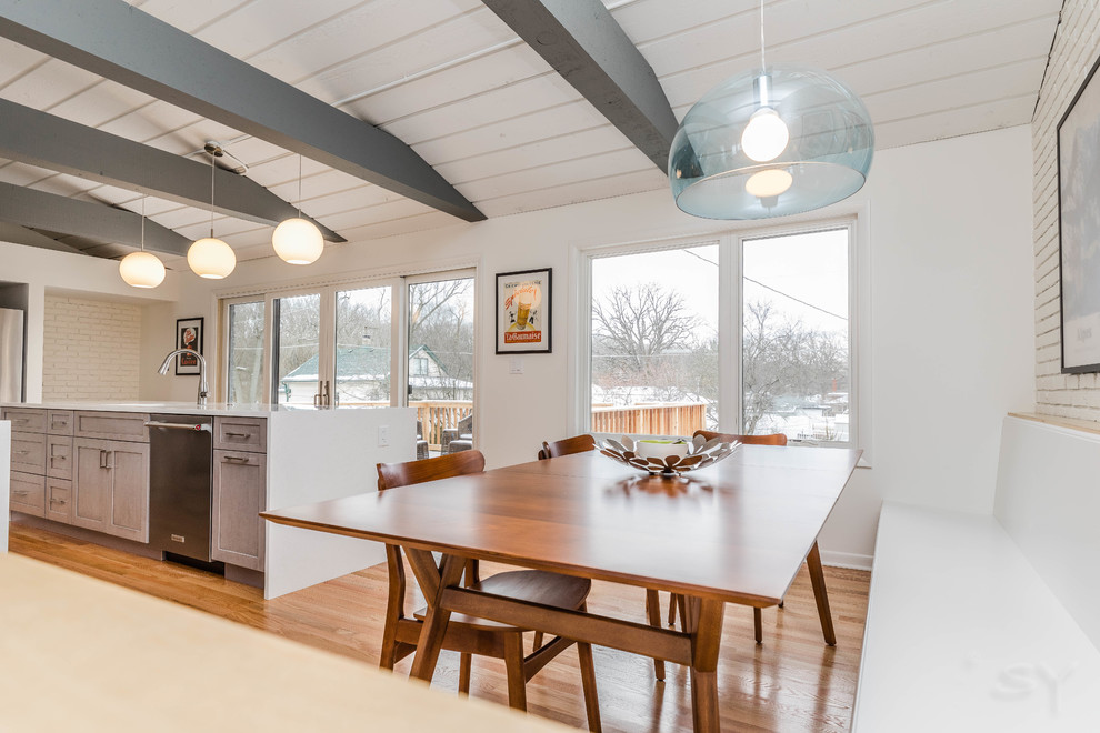 Foto di una piccola sala da pranzo aperta verso la cucina moderna con pareti bianche, pavimento in legno massello medio e pavimento marrone