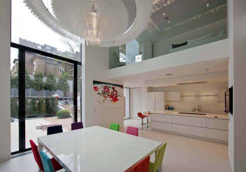 Réalisation d'une salle à manger ouverte sur la cuisine design avec un mur blanc.