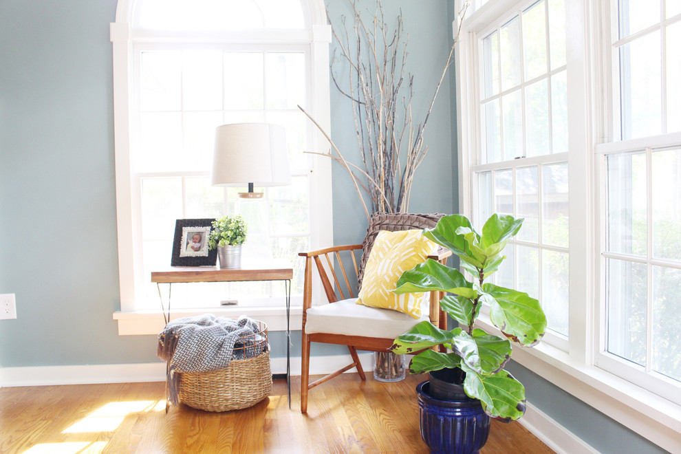 Modelo de comedor campestre de tamaño medio con paredes azules y suelo de madera en tonos medios