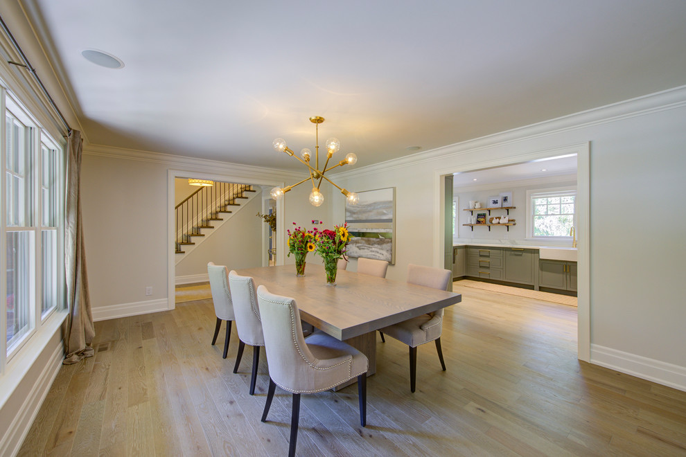 This is an example of a large classic dining room in Toronto with light hardwood flooring and beige floors.