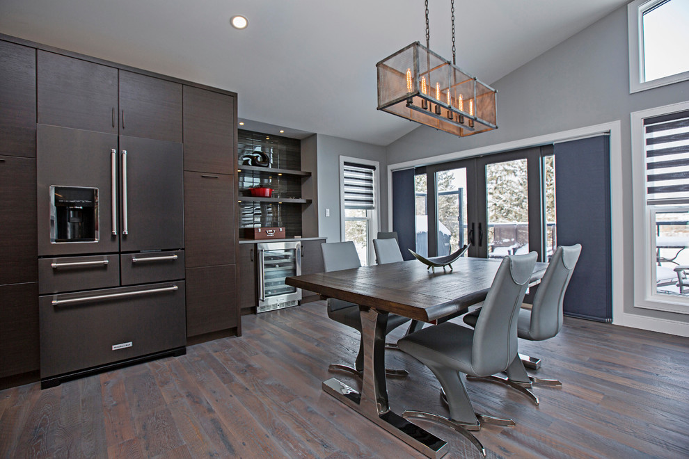 Immagine di una sala da pranzo aperta verso il soggiorno moderna di medie dimensioni con pareti grigie, pavimento in legno massello medio e pavimento grigio