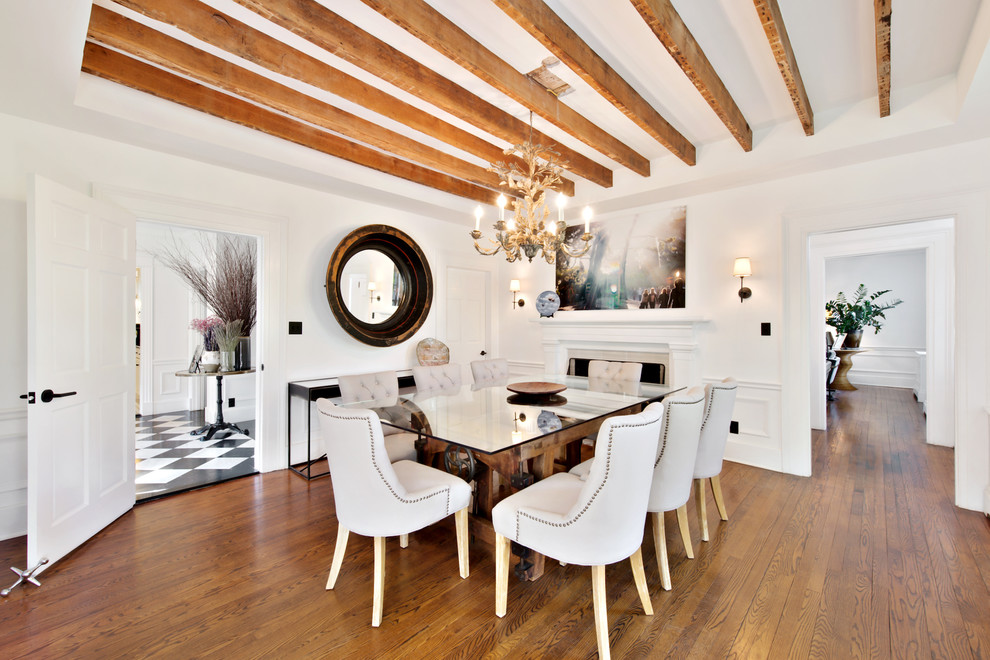Foto di una sala da pranzo tradizionale chiusa con pareti bianche, pavimento in legno massello medio e camino classico