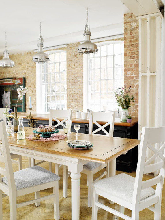 Foto di una sala da pranzo aperta verso la cucina country con pareti marroni, pavimento in legno massello medio, nessun camino e pavimento beige