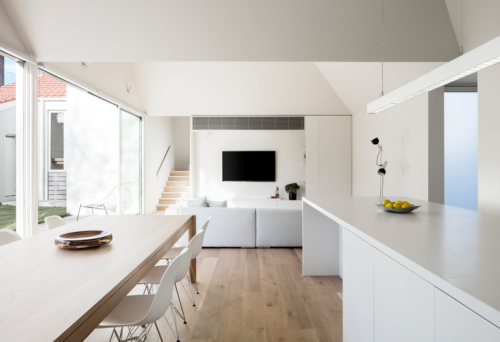 Idées déco pour une salle à manger ouverte sur la cuisine contemporaine de taille moyenne avec parquet clair et un mur gris.