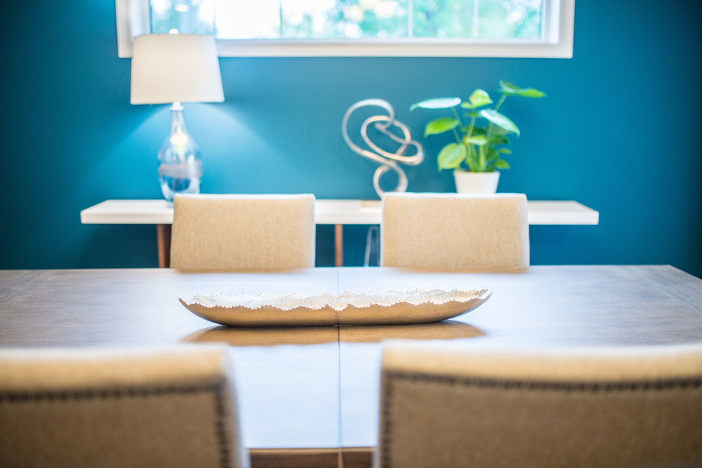 Immagine di una sala da pranzo aperta verso la cucina minimal di medie dimensioni con pareti blu, parquet chiaro e nessun camino