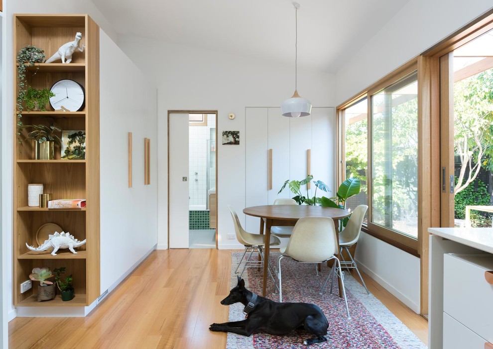 Small scandi kitchen/dining room in Melbourne with white walls, light hardwood flooring and brown floors.