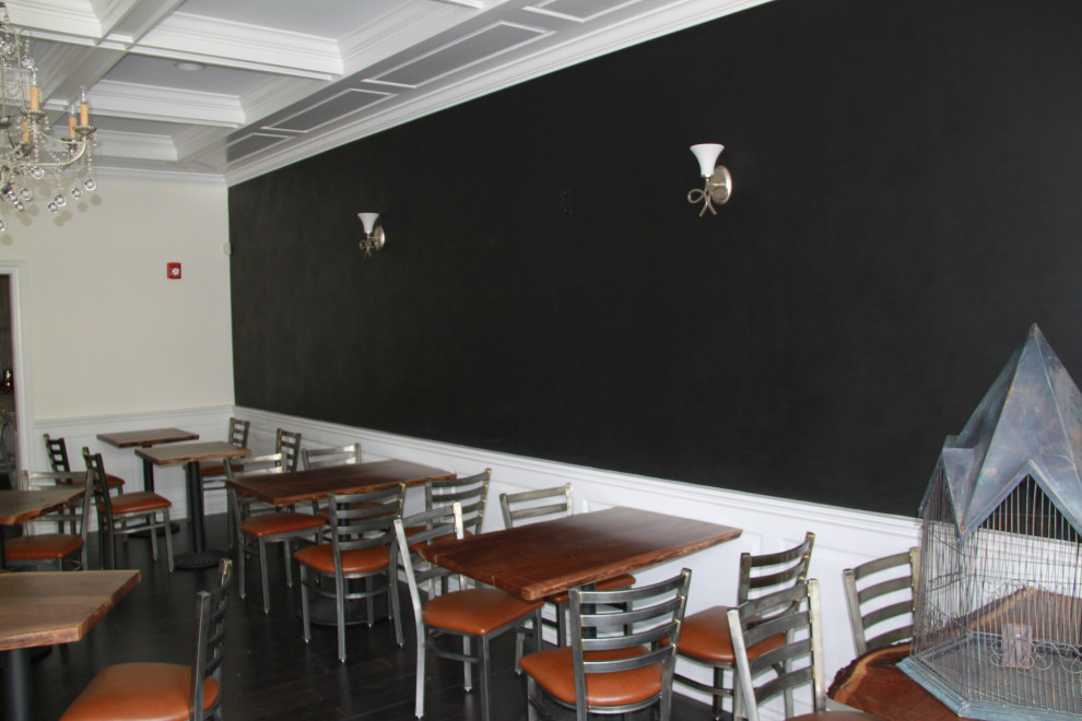Exemple d'une salle à manger ouverte sur la cuisine montagne avec un mur noir.