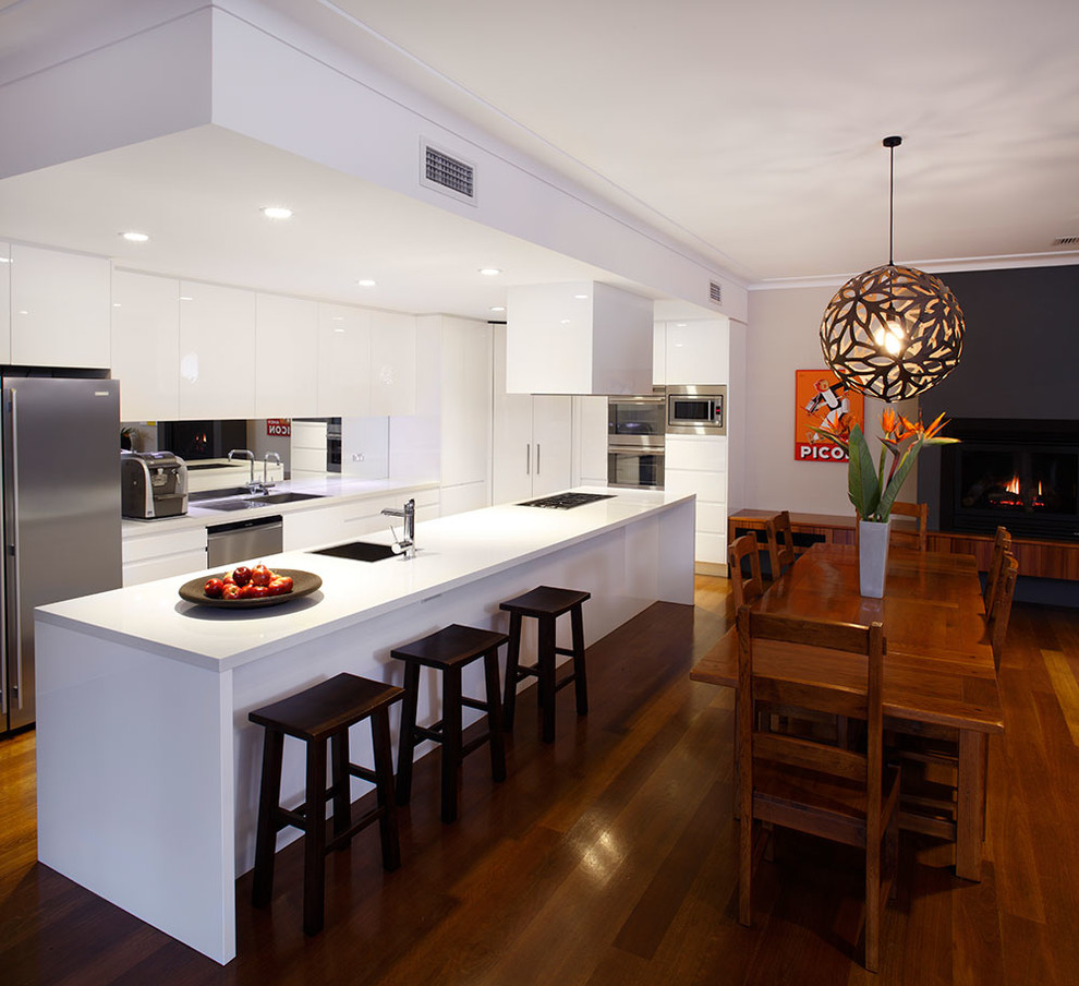 Mid-sized minimalist medium tone wood floor kitchen/dining room combo photo in Sydney with white walls and a ribbon fireplace