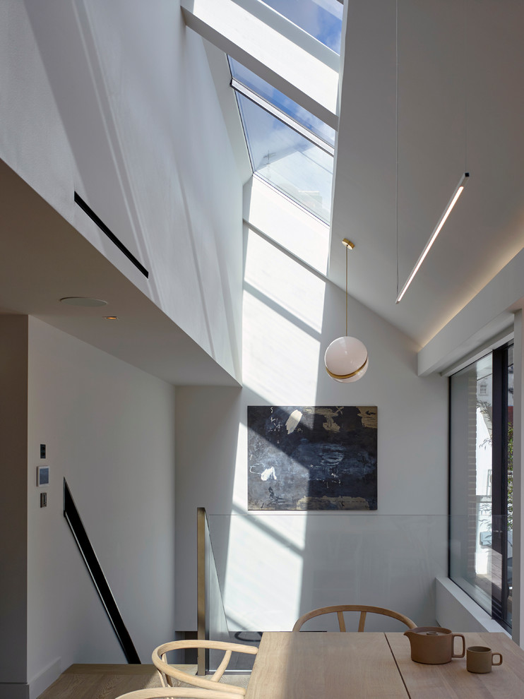 Idée de décoration pour une grande salle à manger ouverte sur le salon design avec un mur gris et parquet clair.