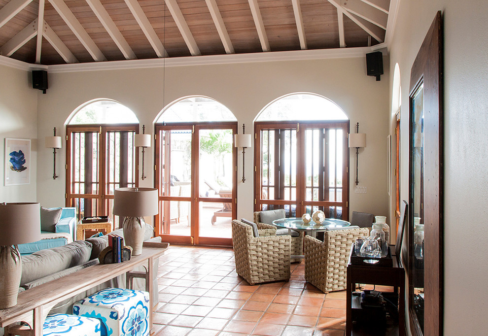 Ejemplo de comedor abovedado tropical abierto con paredes blancas, suelo de baldosas de terracota y suelo naranja