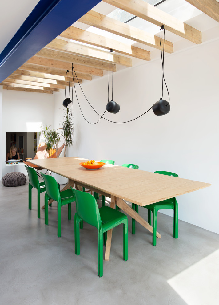 Photo of a scandi dining room in London with white walls, concrete flooring, no fireplace and grey floors.