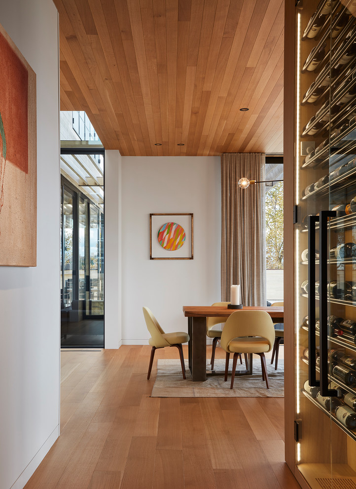 Cette image montre une salle à manger minimaliste avec un sol en bois brun.