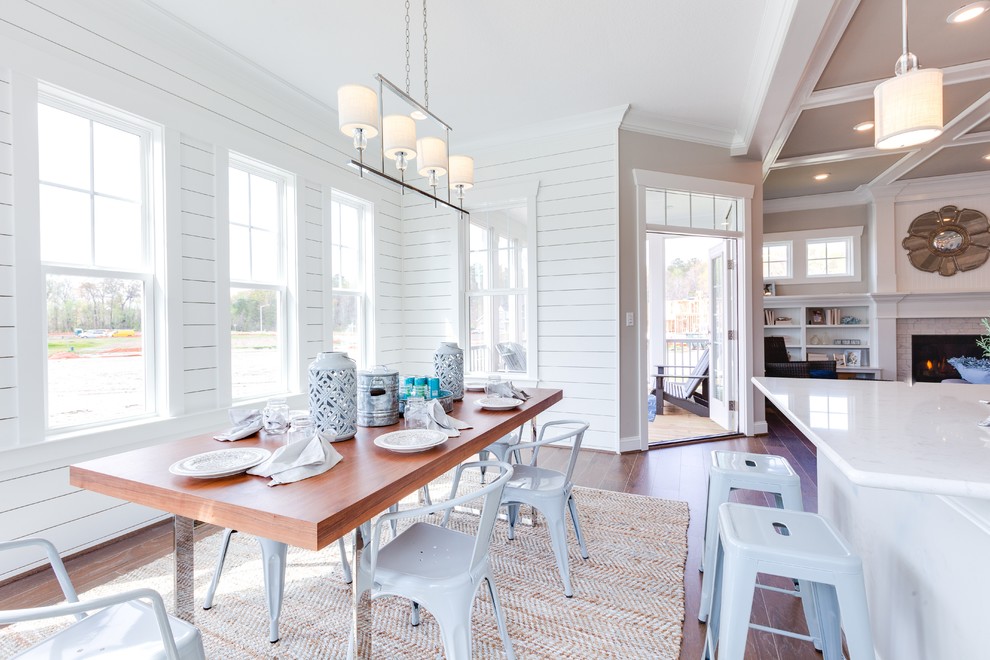 Esempio di una grande sala da pranzo aperta verso la cucina costiera con pareti bianche e pavimento in legno massello medio