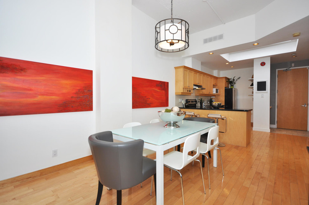 Photo of a medium sized urban kitchen/dining room in Toronto with white walls and light hardwood flooring.