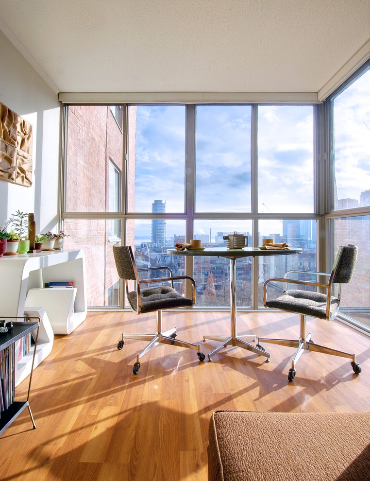 Mid-century modern medium tone wood floor dining room photo in Toronto with white walls
