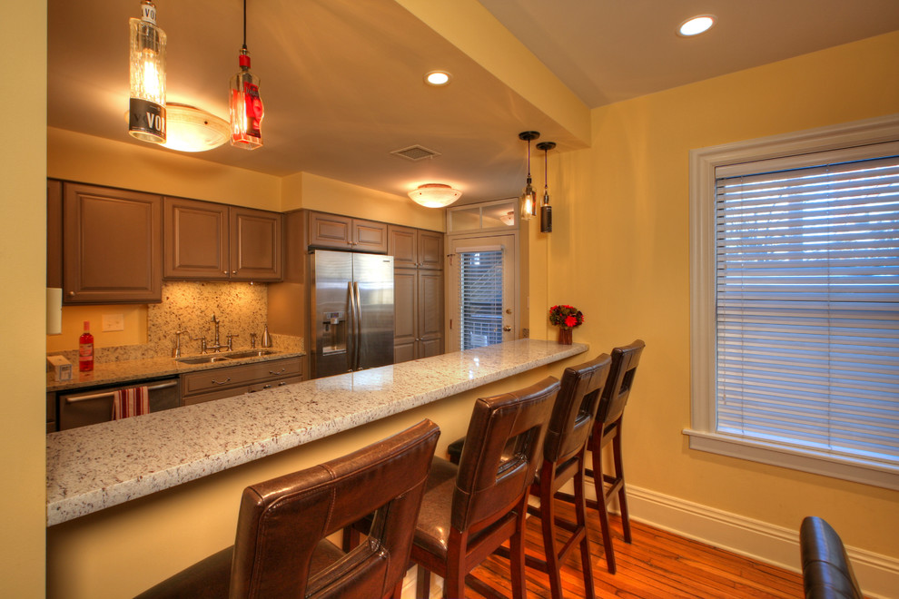 Mittelgroße Moderne Wohnküche mit beiger Wandfarbe, hellem Holzboden, Kamin und Kaminumrandung aus Stein in St. Louis