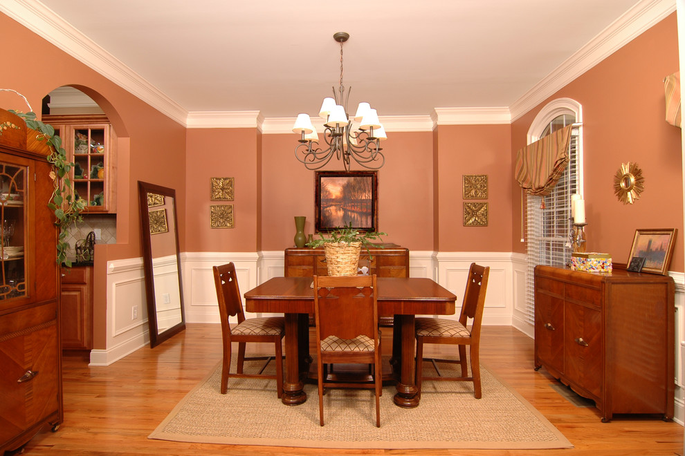 Foto di una sala da pranzo aperta verso la cucina eclettica di medie dimensioni con pareti arancioni, pavimento in legno massello medio, nessun camino e pavimento beige