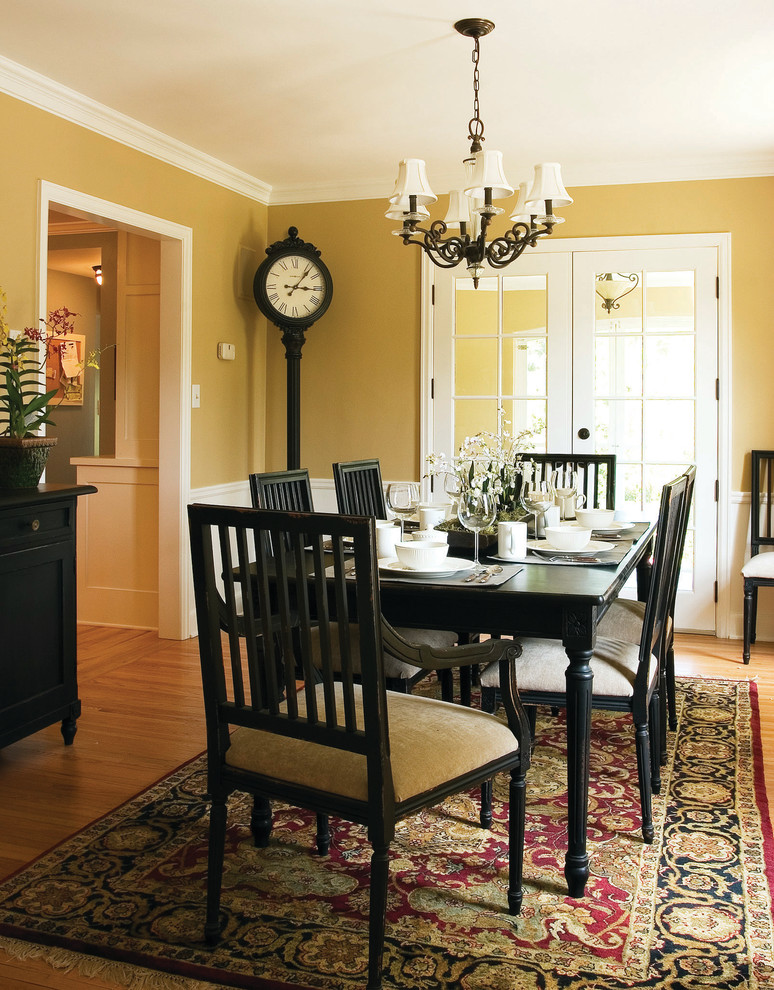 Example of a classic dark wood floor enclosed dining room design in Minneapolis with yellow walls