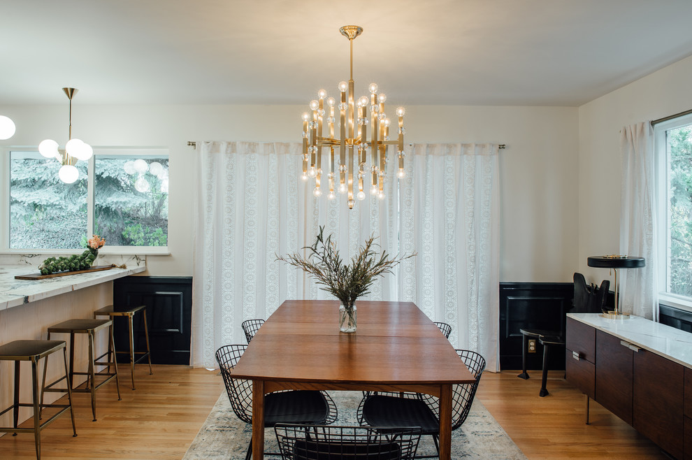 Idée de décoration pour une salle à manger ouverte sur la cuisine bohème de taille moyenne avec un mur blanc et un sol en bois brun.