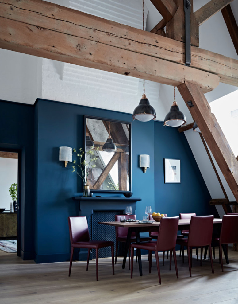 Industriell inredning av en stor matplats med öppen planlösning, med blå väggar, ljust trägolv och beiget golv