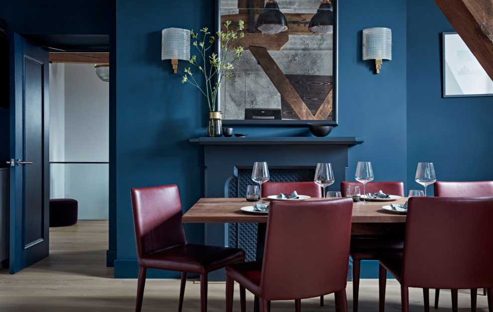 Réalisation d'une grande salle à manger ouverte sur le salon design avec un mur bleu, parquet clair et un sol beige.